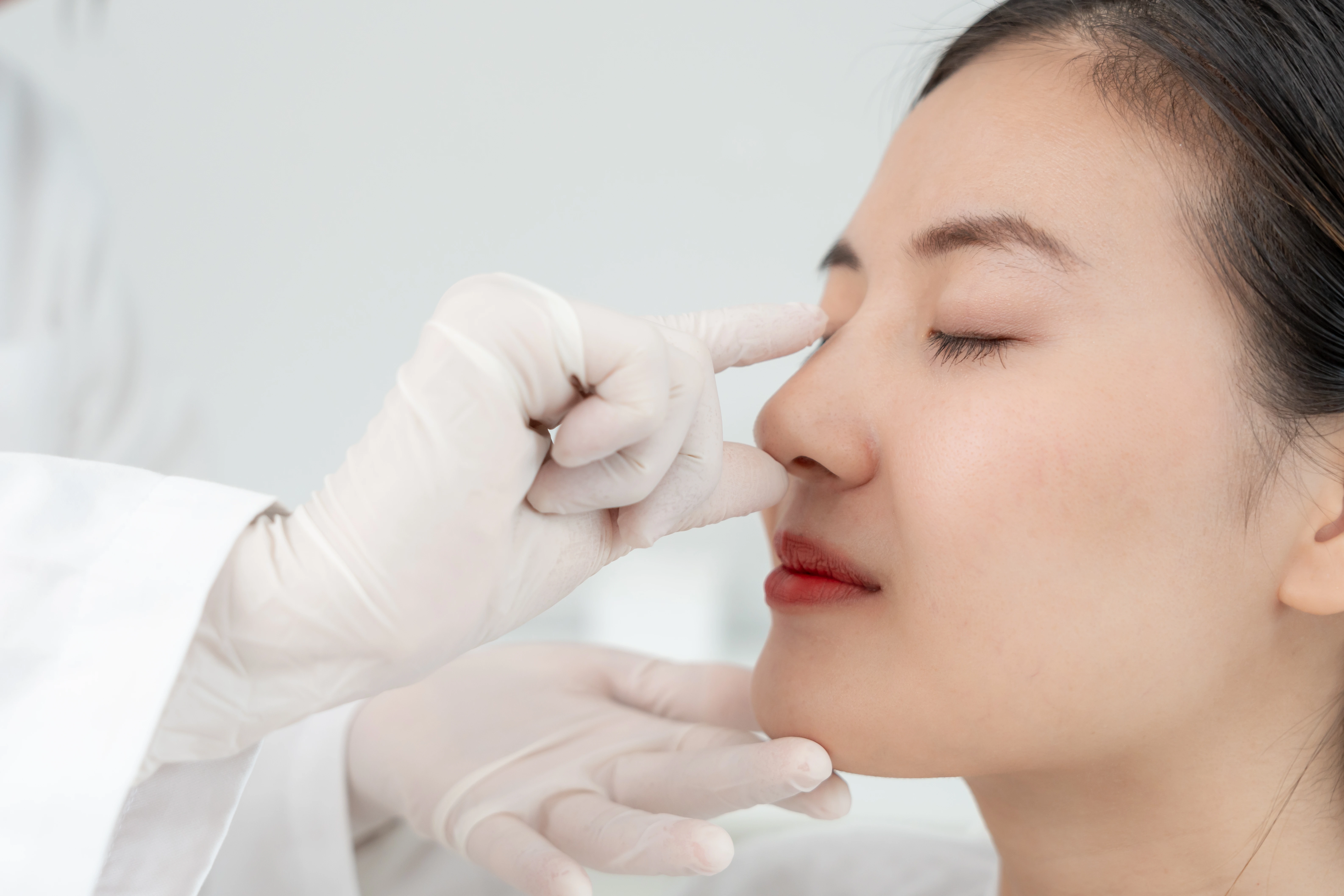 plastic surgery beauty surgeon beautician touching woman face surgical procedure that involve altering shape nose doctor examines patient nose before